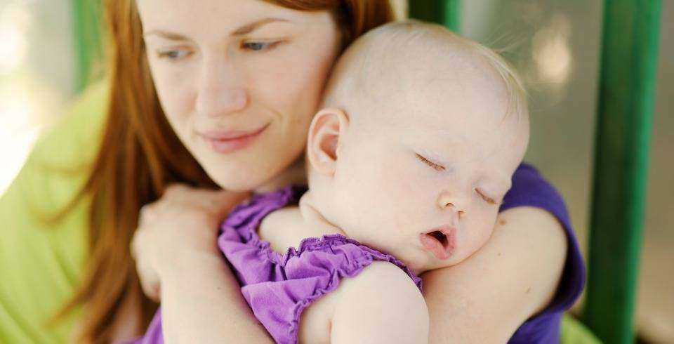 Mama cu bebelus dormind in brate