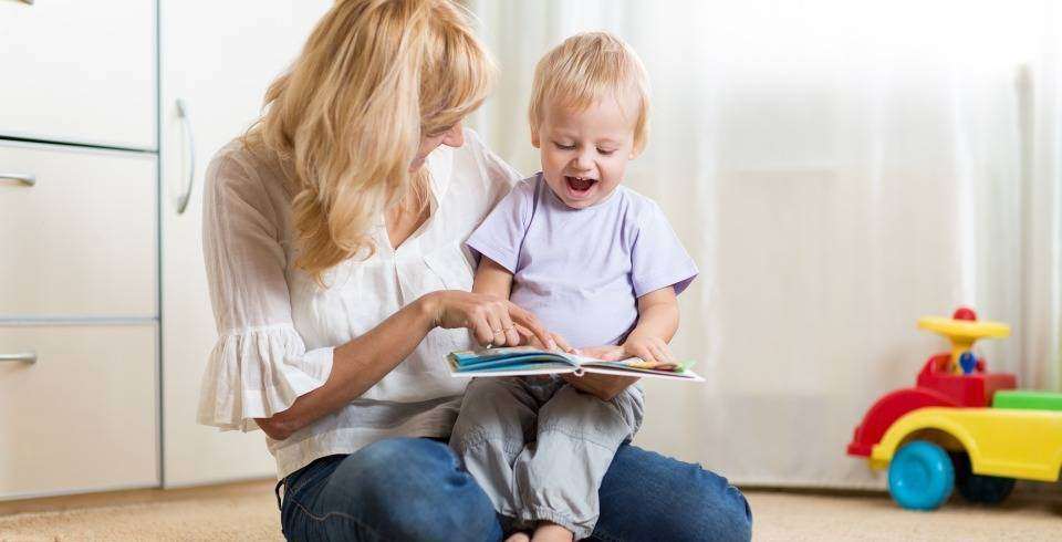 Mama cu baietel fericit ii arata in carte