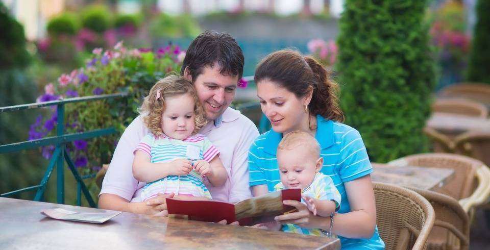 Familie cu 2 copii la masa la resuatrant, terasa